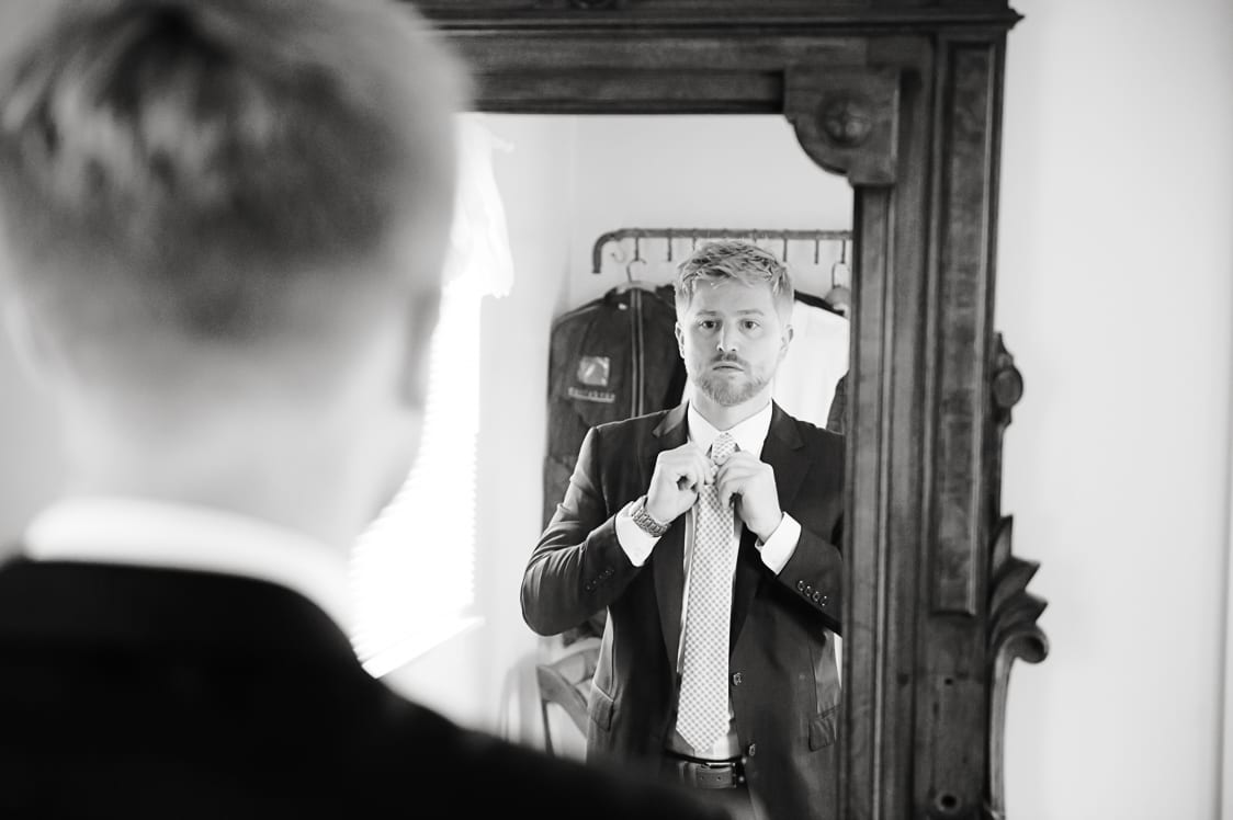 Groom looking in the mirror at Maplehurst Farms