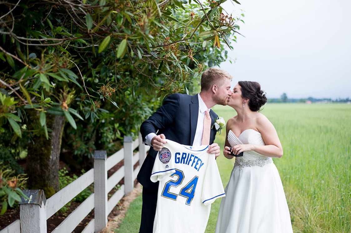 Bride and groom kiss while groom holds Ken Griffey Jr Jersey