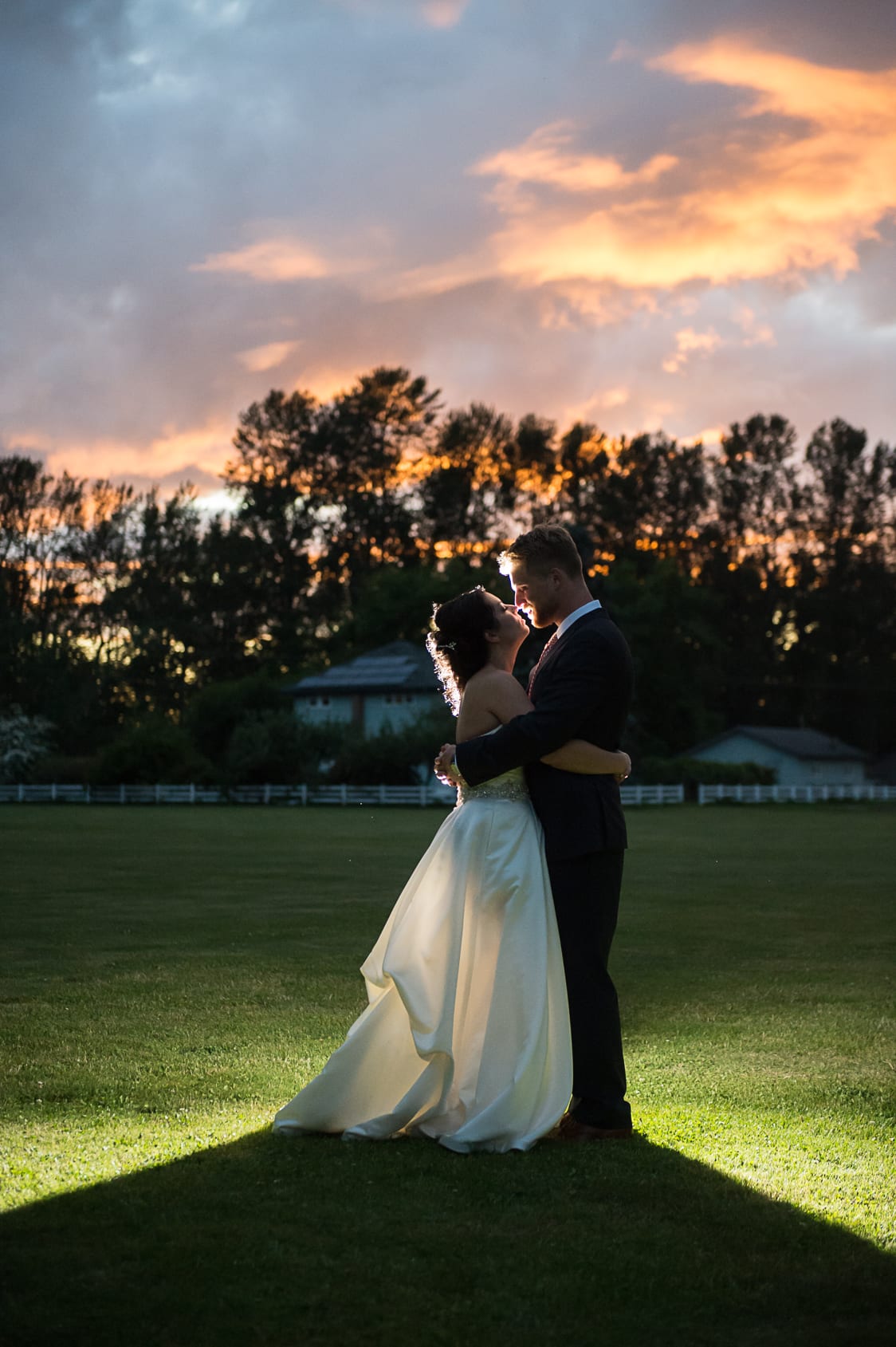 Bride and groom backlit at sunset at Maplehurst Farm