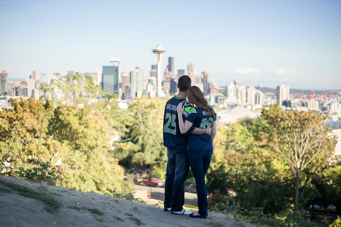 engaged couple wearing seahawks jerseys at Kerry Park in Seattle