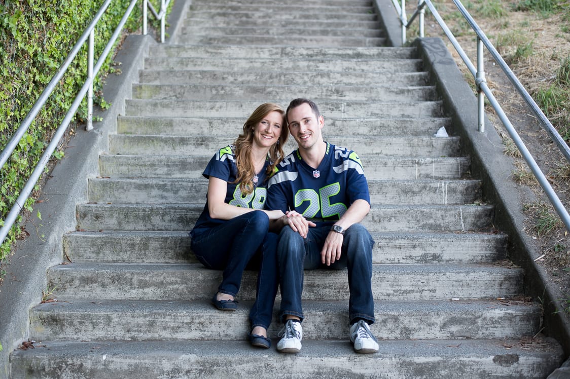 Couple sitting on step at Kerry Park in Seattle during their engagement session