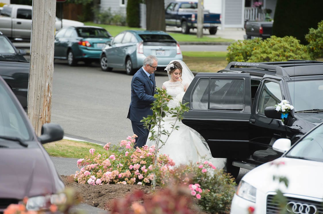 Father helping his daughter out of the car on her wedding day