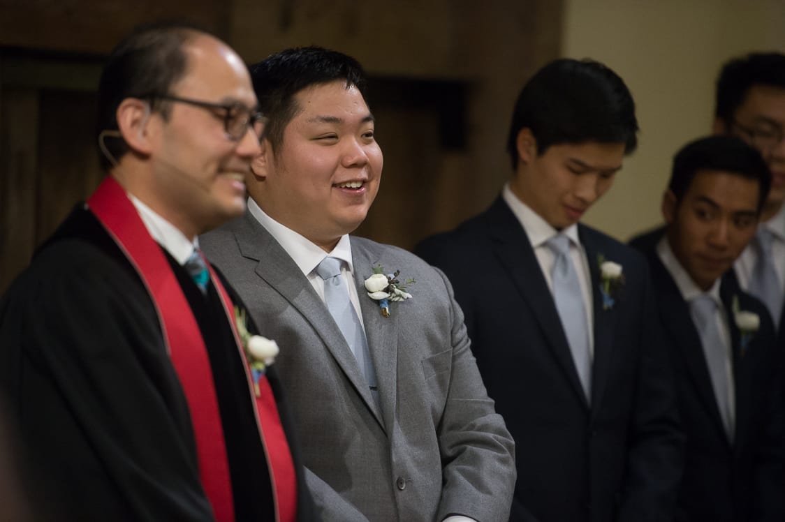 Groom smiling as his bride walks down the aisle at the Pickering Barn in Issaquah, WA