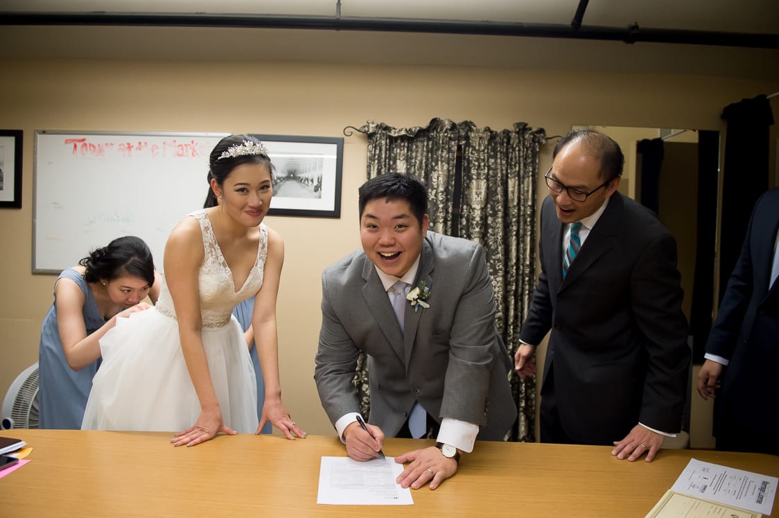 Groom laughing while signing wedding license at the Pickering Barn in Issaquah, WA