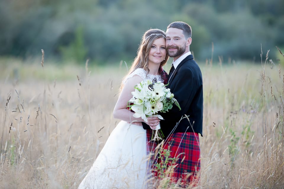 Bride and groom close together in a field at Selene Homestead