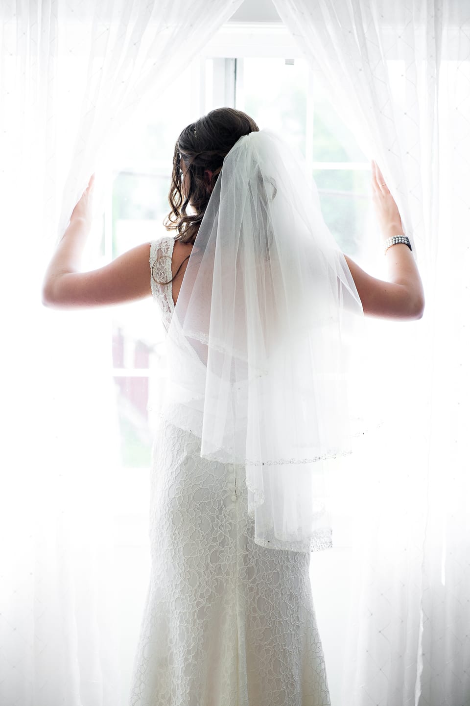 Bride looking out the window at The Grand Willow Inn
