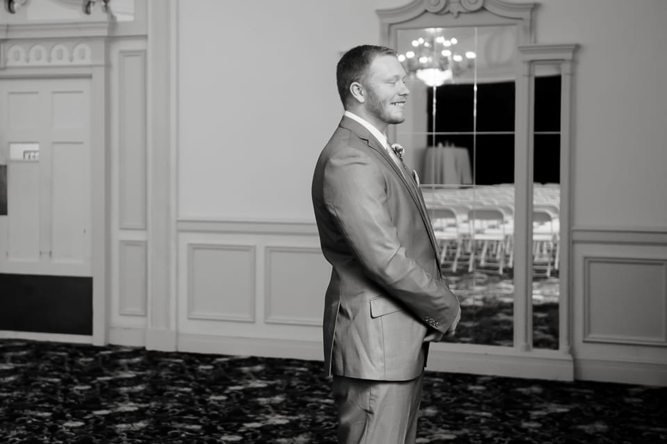 Groom smiles as he waits to see his bride at the Leopold Crystal Ballroom