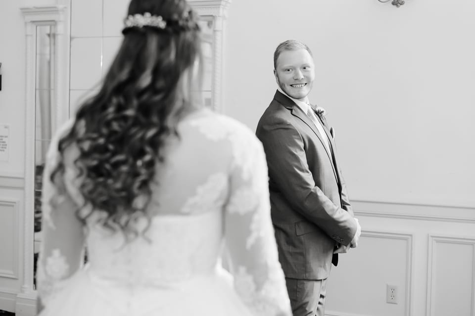 Groom smiles as he sees his bride at the Leopold Crystal Ballroom