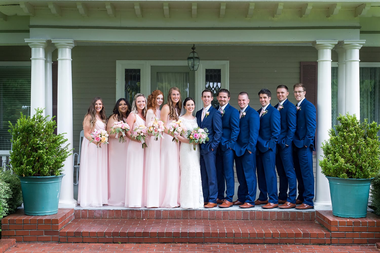 Entire wedding party in front of the house at Maplehurst Farm wedding venue