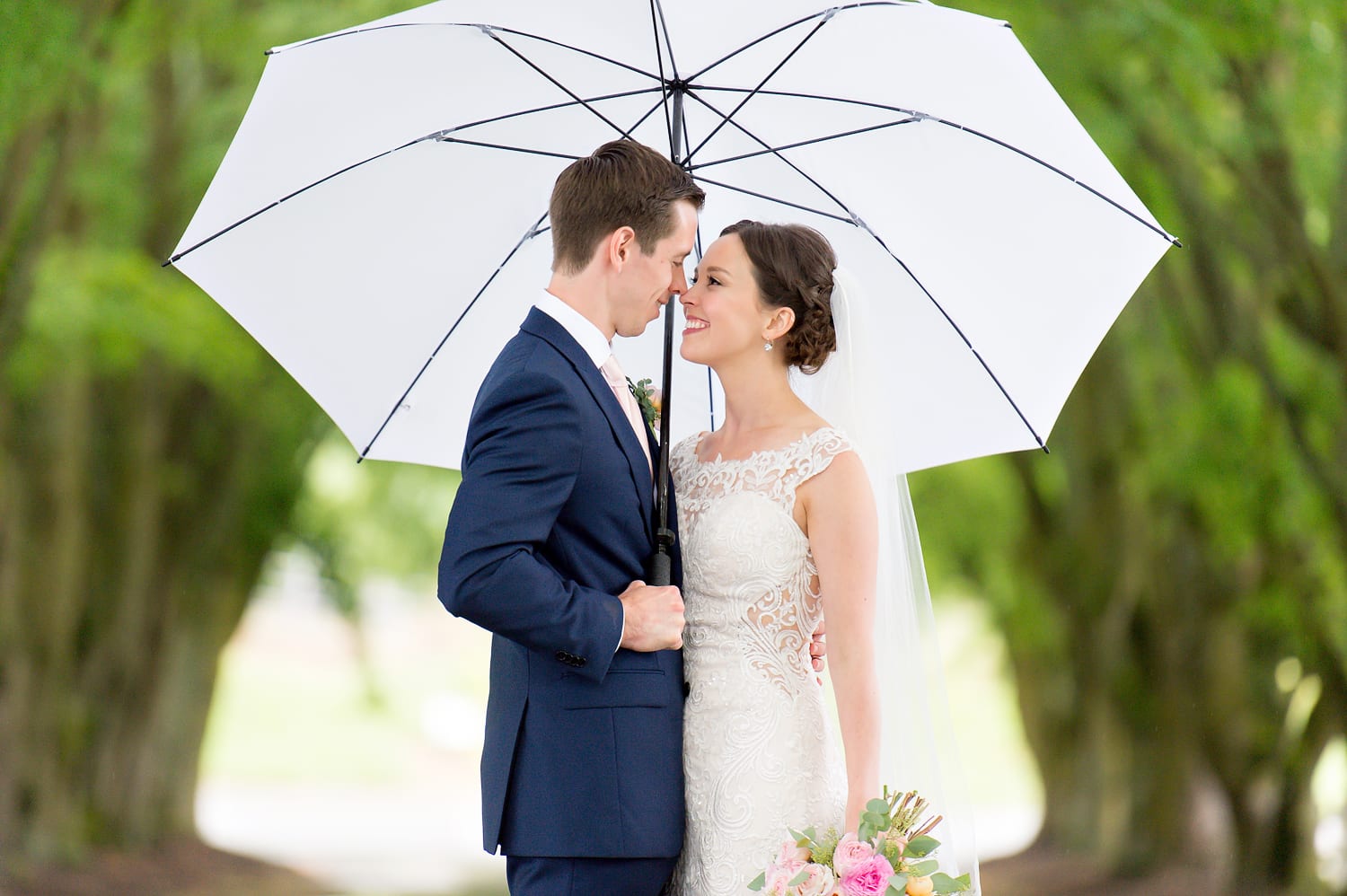 Bride and groom with umbrella at Maplehurst Farm wedding venue